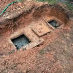 Two entry point holes into a residential backyard septic tank.