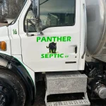 The words "Panther Septic LLC" are written on the door of a vacuum pump truck.