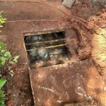 A close-up of an entry hole point to a septic tank.