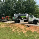 A vacuum truck with big neon green words written on it "Panther Septic LLC" sits outside a residential home.