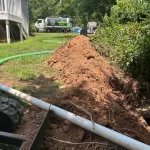 A septic tank drainage pipe snakes through a residential backyard.