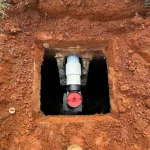 Close-up of an entry point to a septic tank, located in a residential backyard.